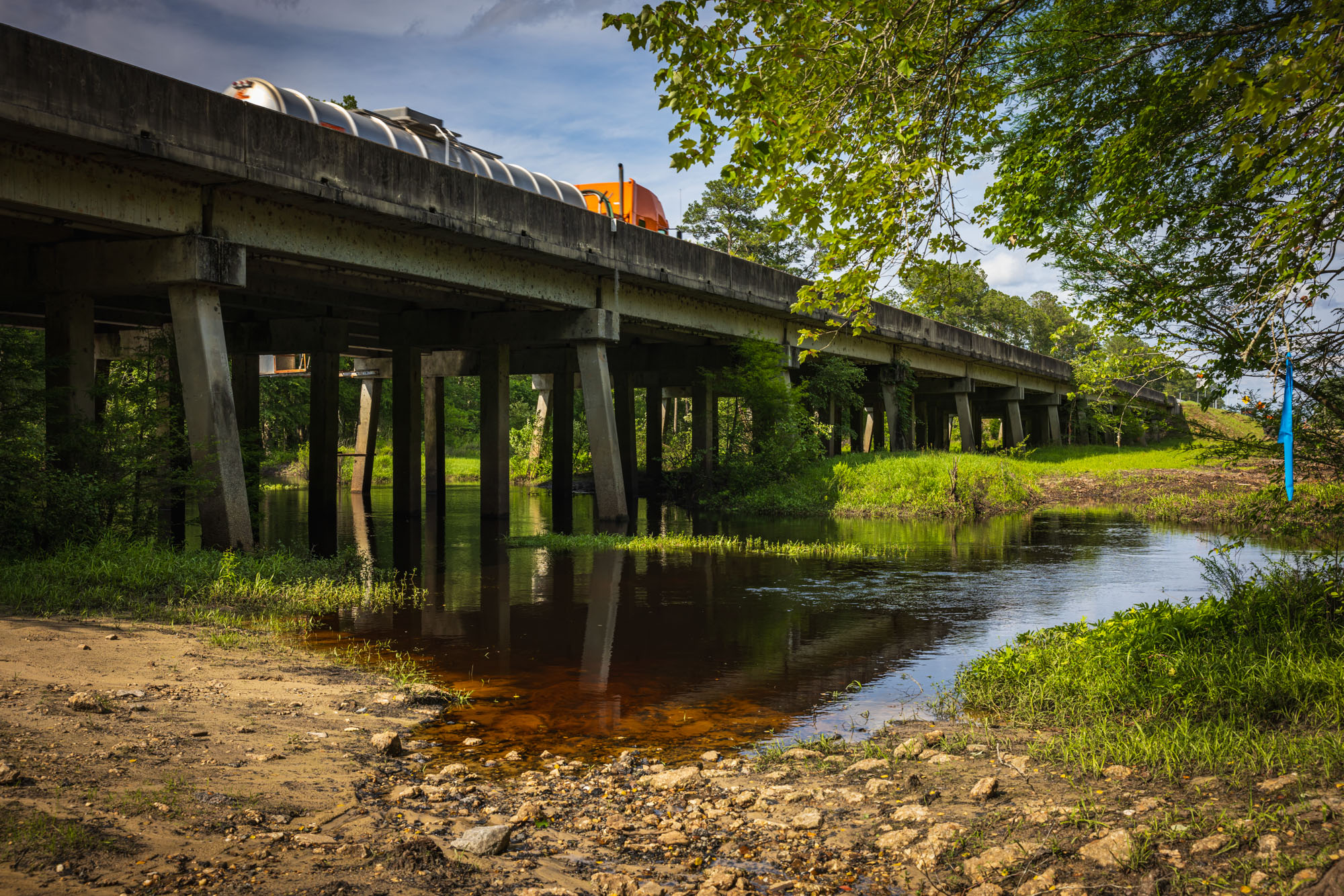 A bridge over a creek is pictured. A bridge over a creek is pictured.