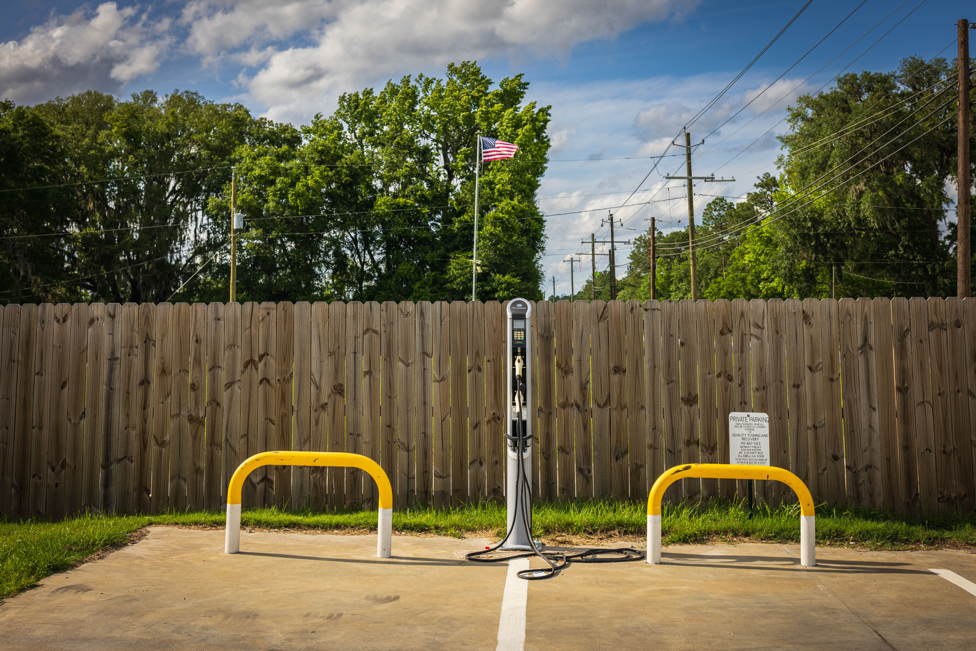 An electric vehicle charging station is pictured in a parking lot. An electric vehicle charging station is pictured in a parking lot.