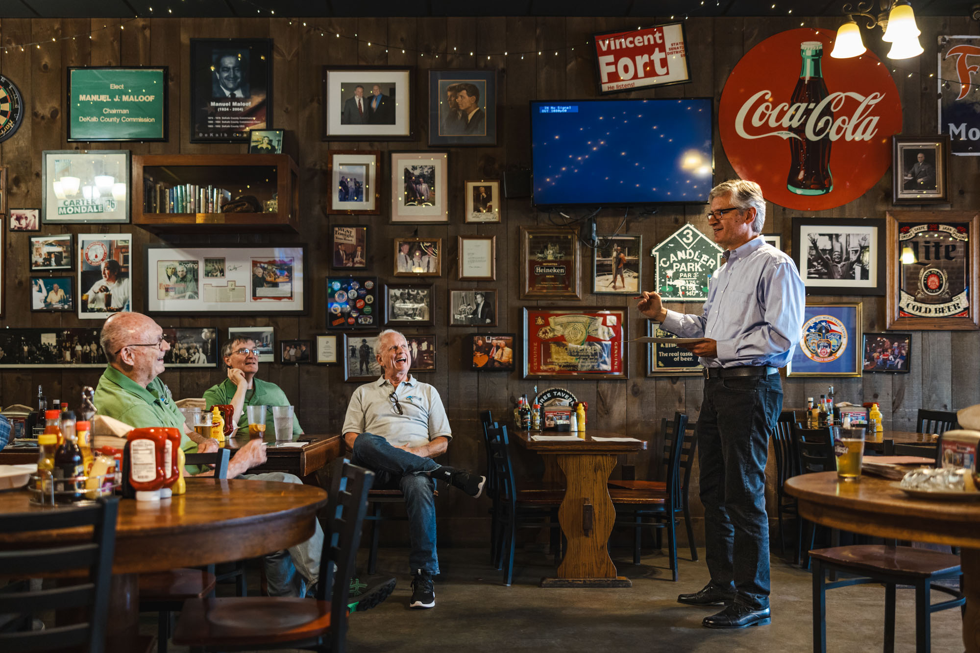 Chris Campbell (right) speaks to a group of three men in a tavern. Chris Campbell (right) speaks to a group of three men in a tavern.